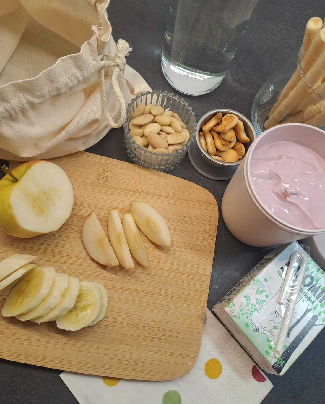 A soft cotton Snack Kit pouch filled with healthy snacks — grapes, crackers, and carrot sticks — styled in a calm, minimalist setting by Bright Balance Studio.